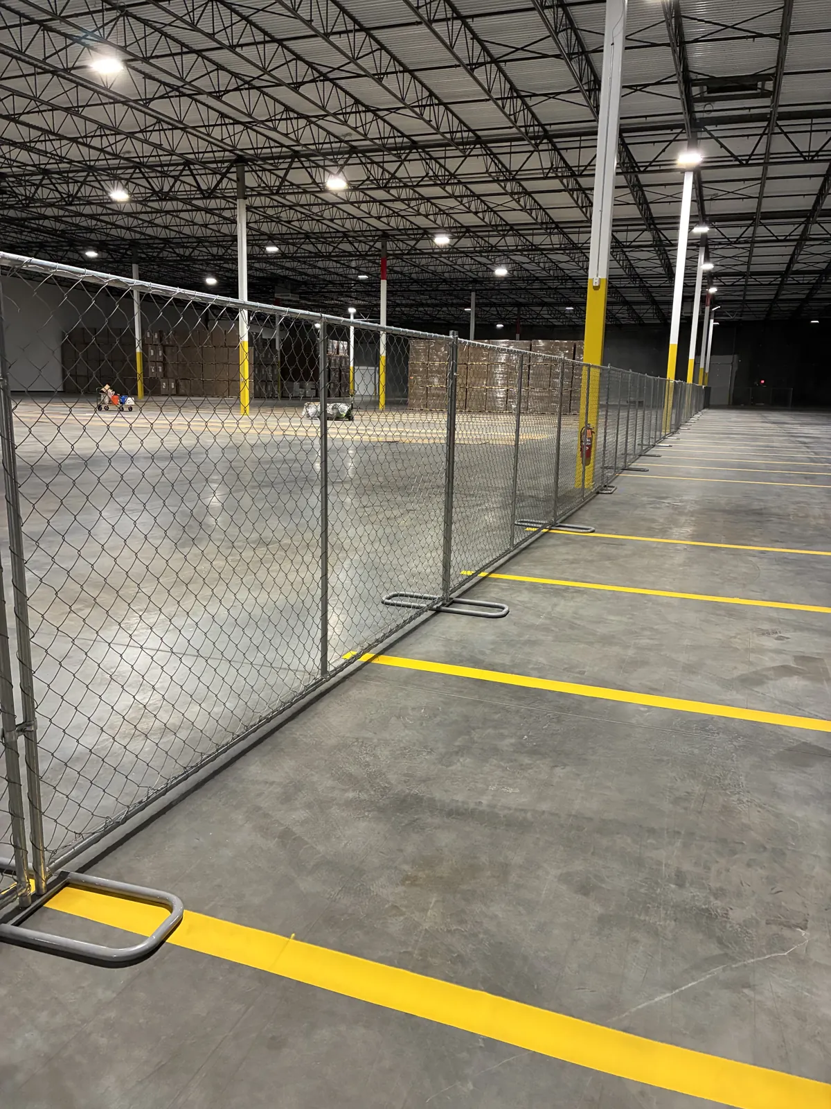Chain link temporary fencing installed along a wall to secure a job site