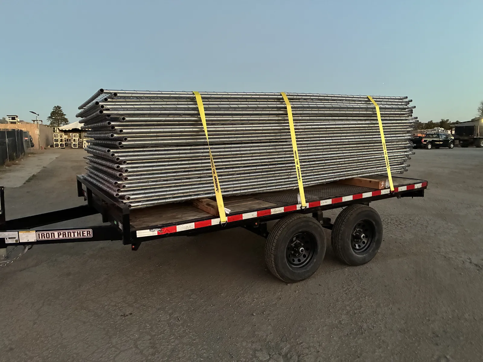 Temporary fence panels loaded on a flatbed at golden hour ready for delivery