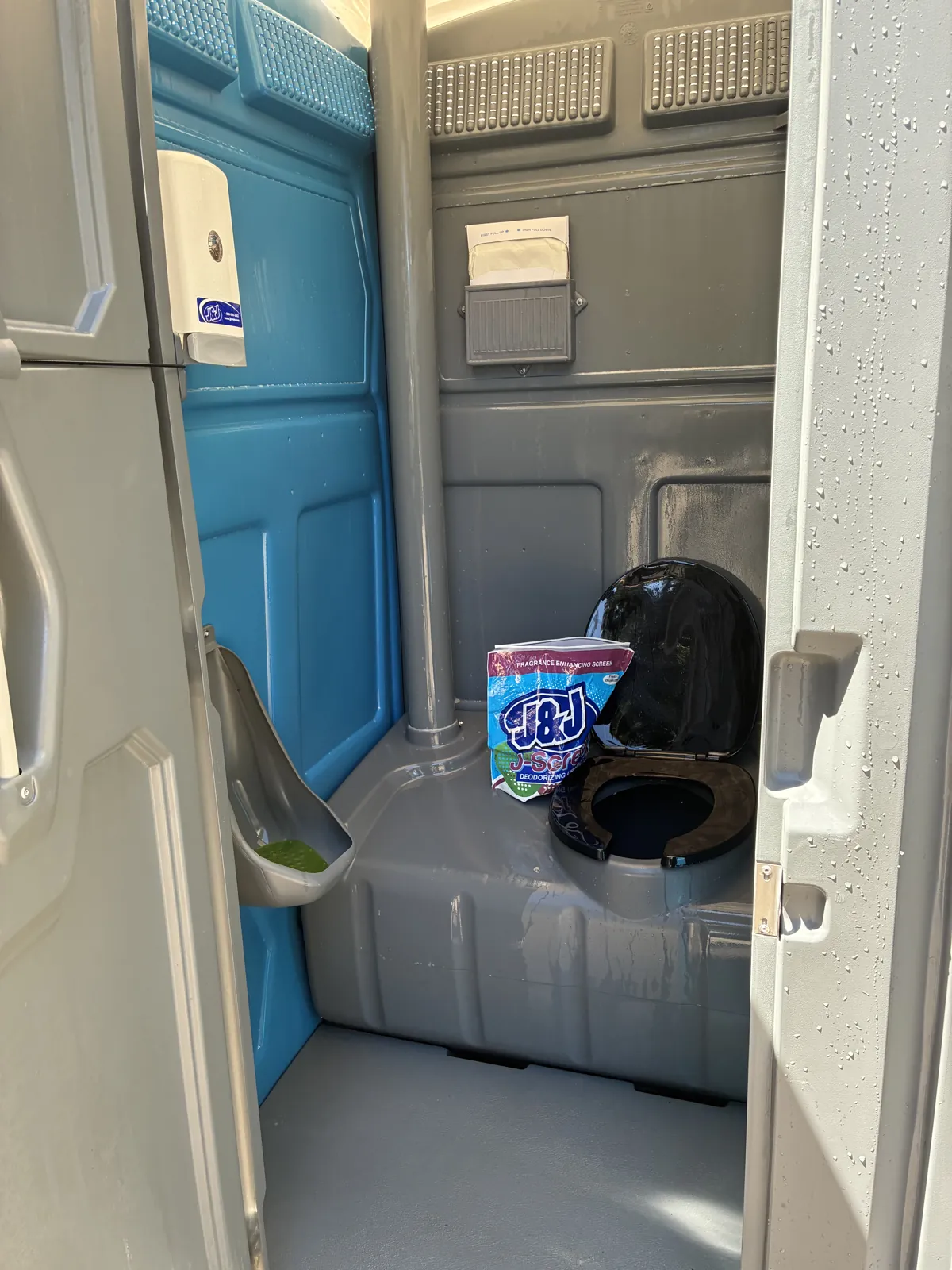 A clean Pro Portable Restrooms interior with a hand sanitizer dispenser stocked