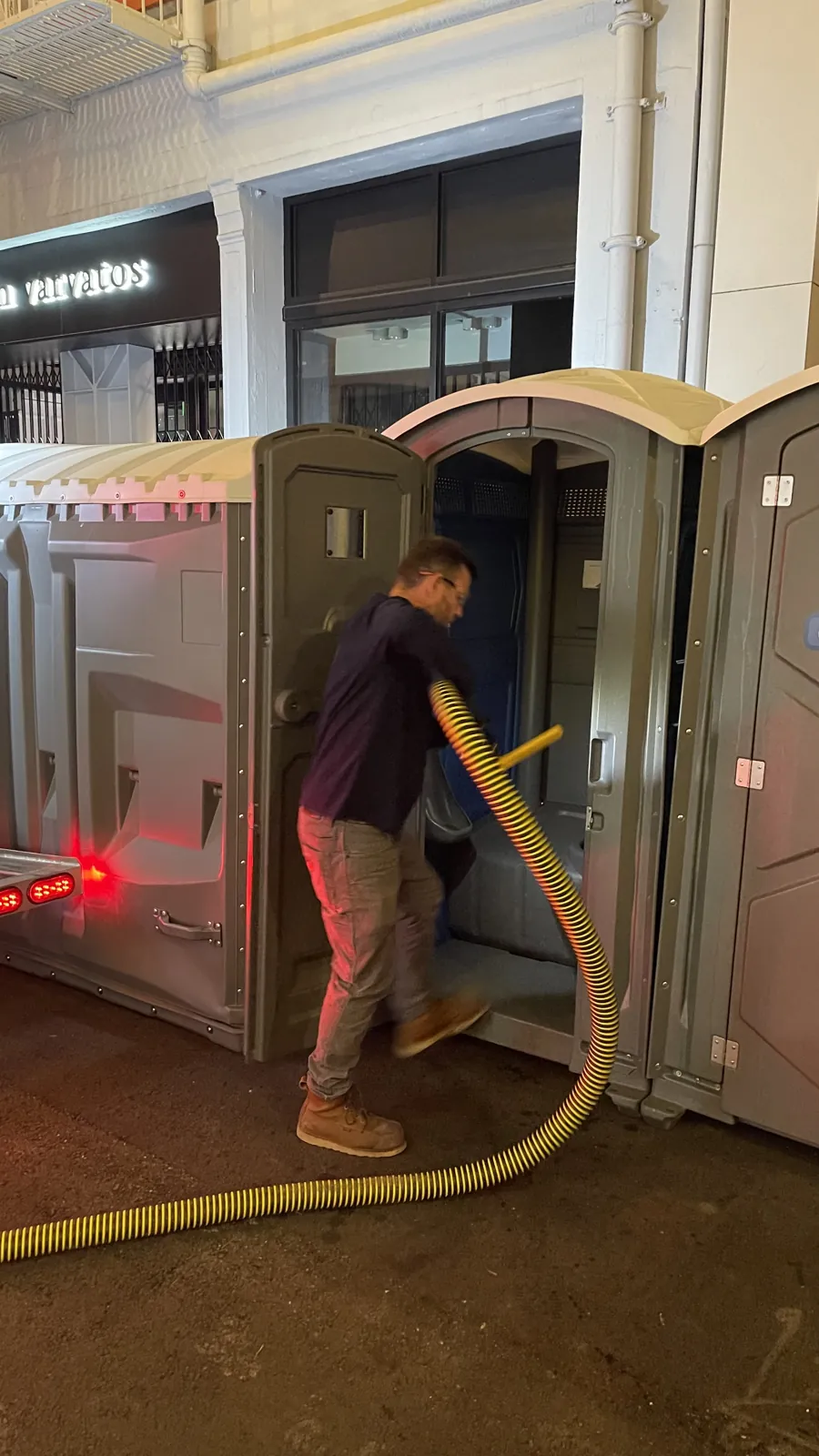 A Pro Portable Restrooms technician servicing and pumping a unit on site