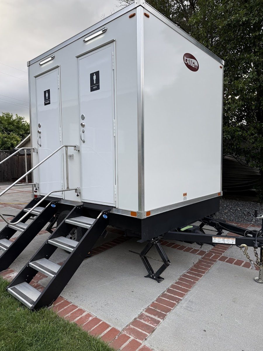 A clean multi-stall luxury restroom trailer with private entrances and steps
