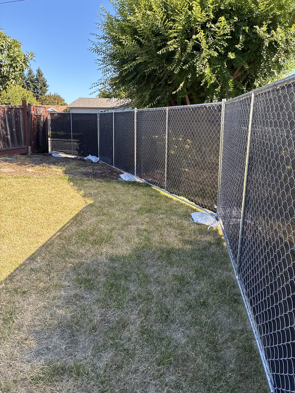 A Pro Portable Restrooms truck towing a trailer stacked with chain-link fence panels for delivery