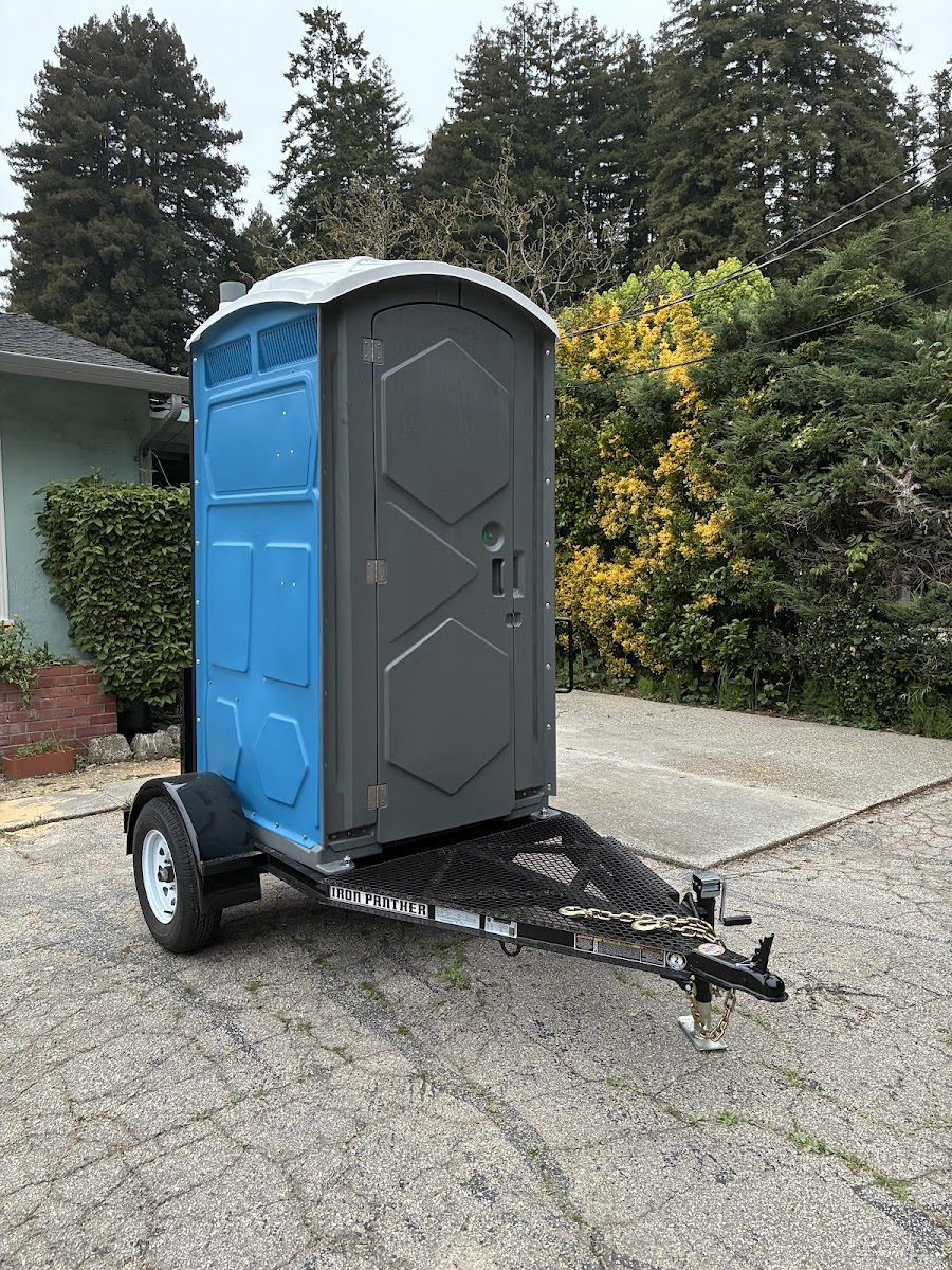 A clean porta potty positioned at an outdoor job site