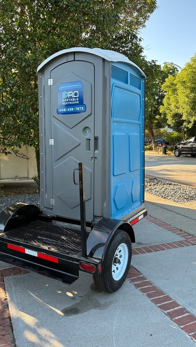 A towable porta potty unit on a delivery trailer