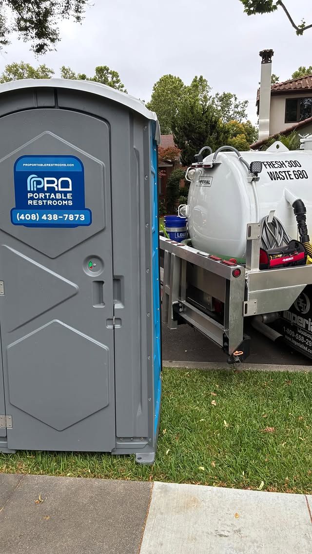 A porta potty and Pro Portable Restrooms service truck at a delivery site